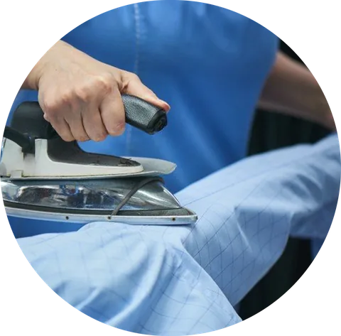 Pressing a blue shirt with a steam iron